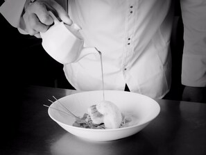 A person pouring a liquid into a bowl with a whisk. - Logis Hôtel de France Restaurant le Lucullus (Montmorillon)