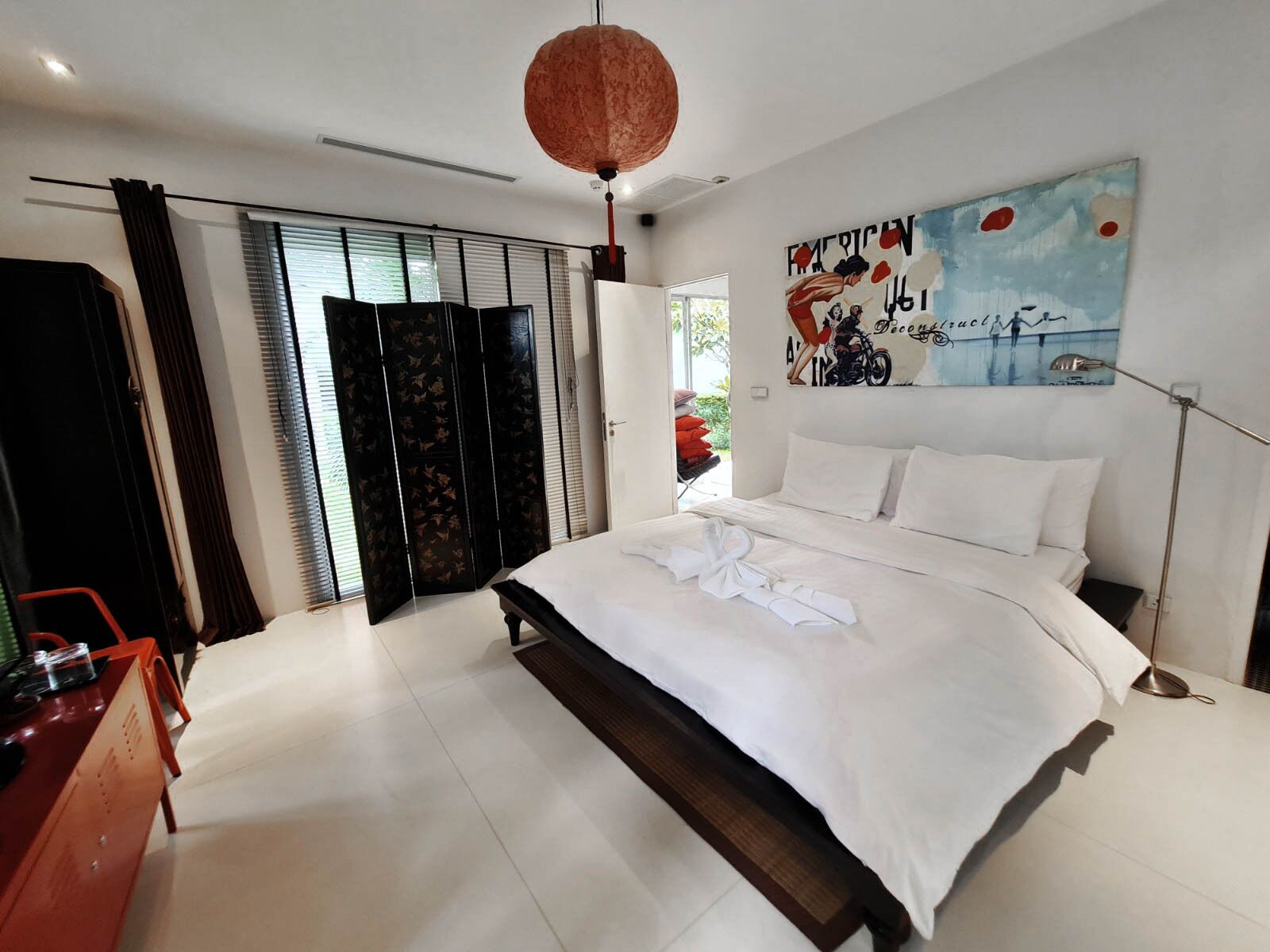 Une chambre moderne avec un grand lit, une armoire et un tableau au mur.