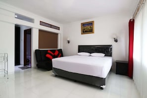 A bedroom with a bed, a chair, a door, and a painting on the wall. - Narima Resort Hotel (Lembang)