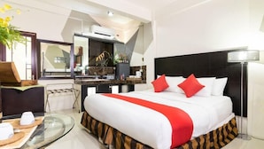 Une chambre d’hôtel moderne équipée d’un grand lit, d’un bureau et d’une kitchenette.