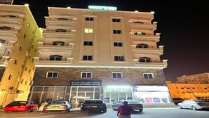 A multi-story building with a sign for electrical equipment sale. - Super OYO 144 Al Tawasi Furnished Apartments (Salalah)