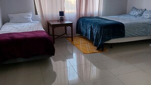 A room with two beds, a small table, and a chair. - Special Inn Bed and Breakfast  (Windhoek)
