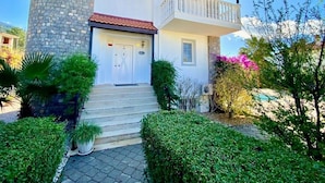 A two-story house with a stone facade, a balcony, and a front door. - Private Villa ErzanMyne Private Pool Mountain View Ovacik Oludeniz (Muğla)