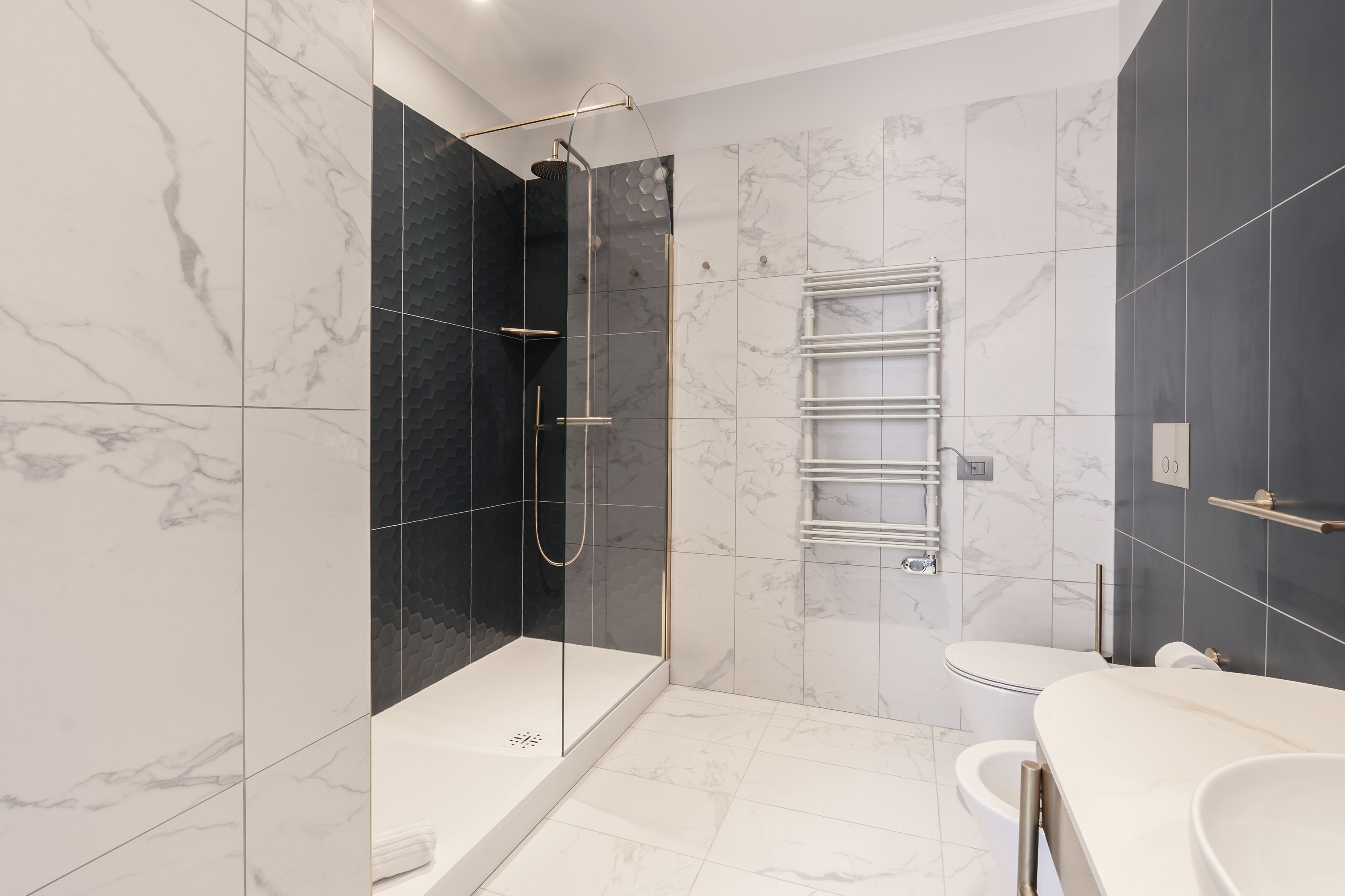 A modern bathroom with a glass-enclosed shower, a white toilet, and a vanity with a sink.