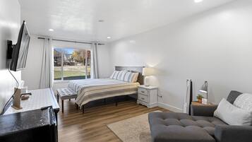 Una camera da letto moderna con un letto, comodini, una scrivania e un televisore.