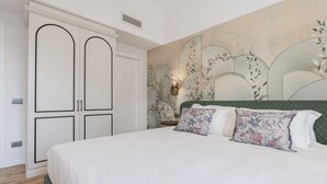 A bedroom with a bed, a wardrobe, and a wall with a floral design. - Be Mate Trastevere II (Rome)