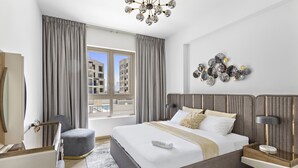 A modern hotel room with a large bed, a bedside table, a chair, and a view of the city. - WelHome - Incredible Waterfront Apt With Mesmerizing views (Dubai)