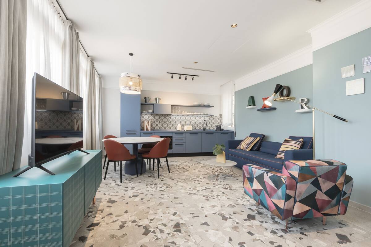 Un salon moderne comprenant un canapé, une table basse et un coin repas avec des chaises et une table.