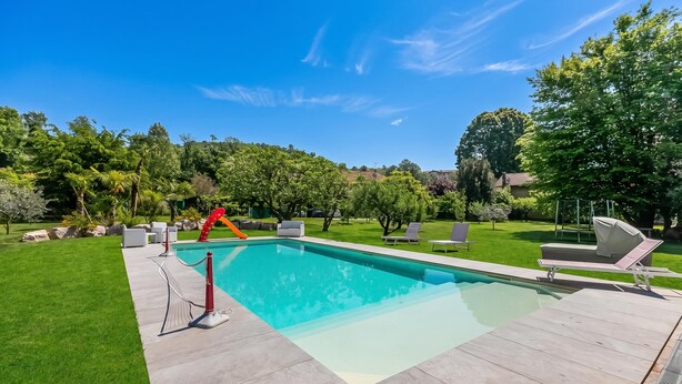 A rectangular swimming pool with a tiled deck, surrounded by a well-maintained lawn and trees. - Anita Lake, 2BR Retreat w/ Shared Pool and Gym (Gemonio)