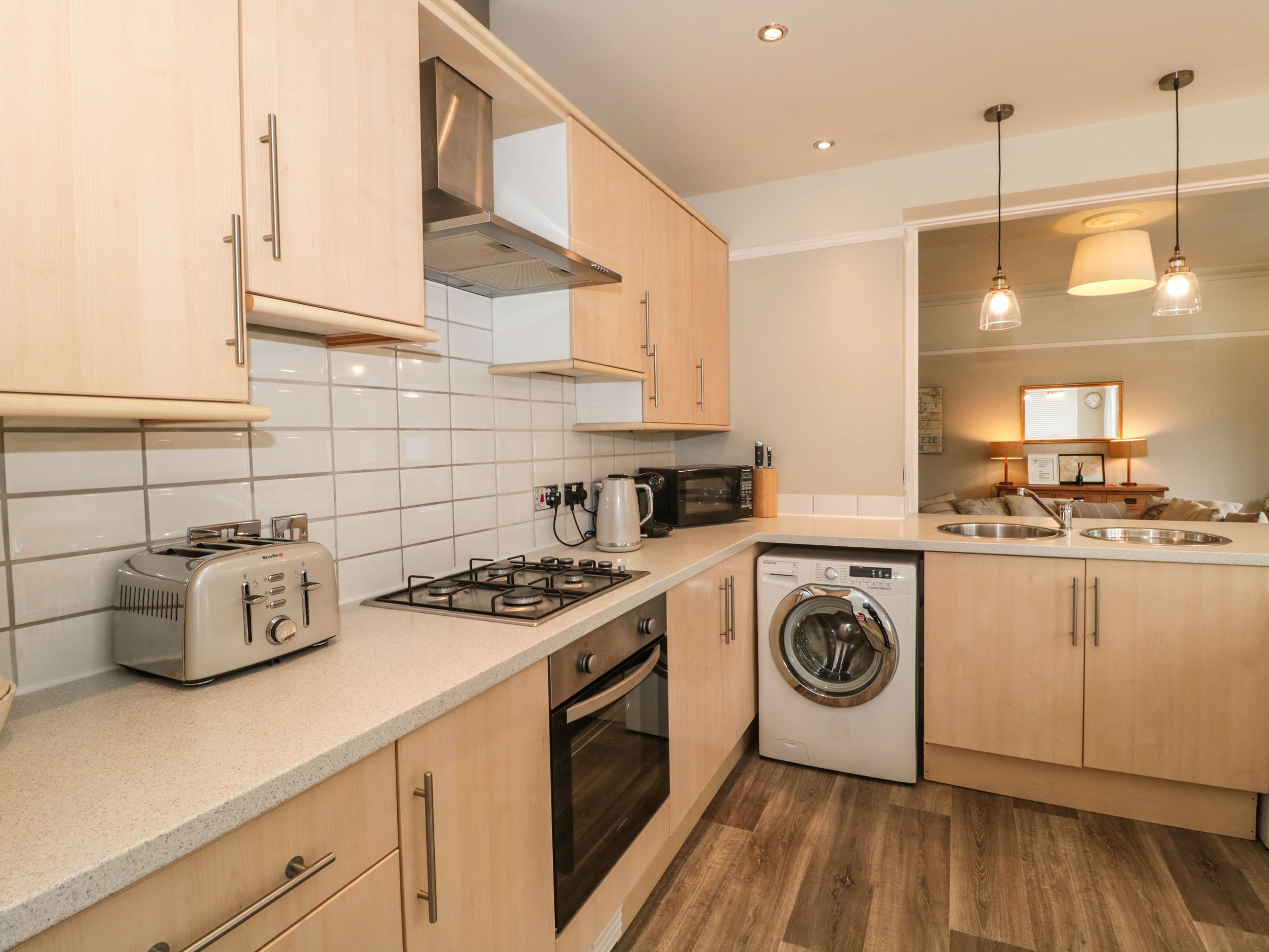 A modern kitchen with a toaster, microwave, stove, oven, and washing machine.