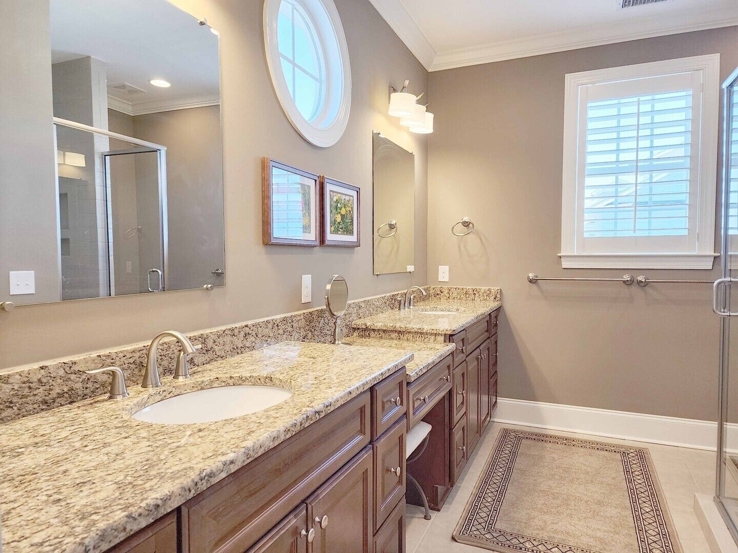 A bathroom with two sinks, a large mirror, and a window with blinds.