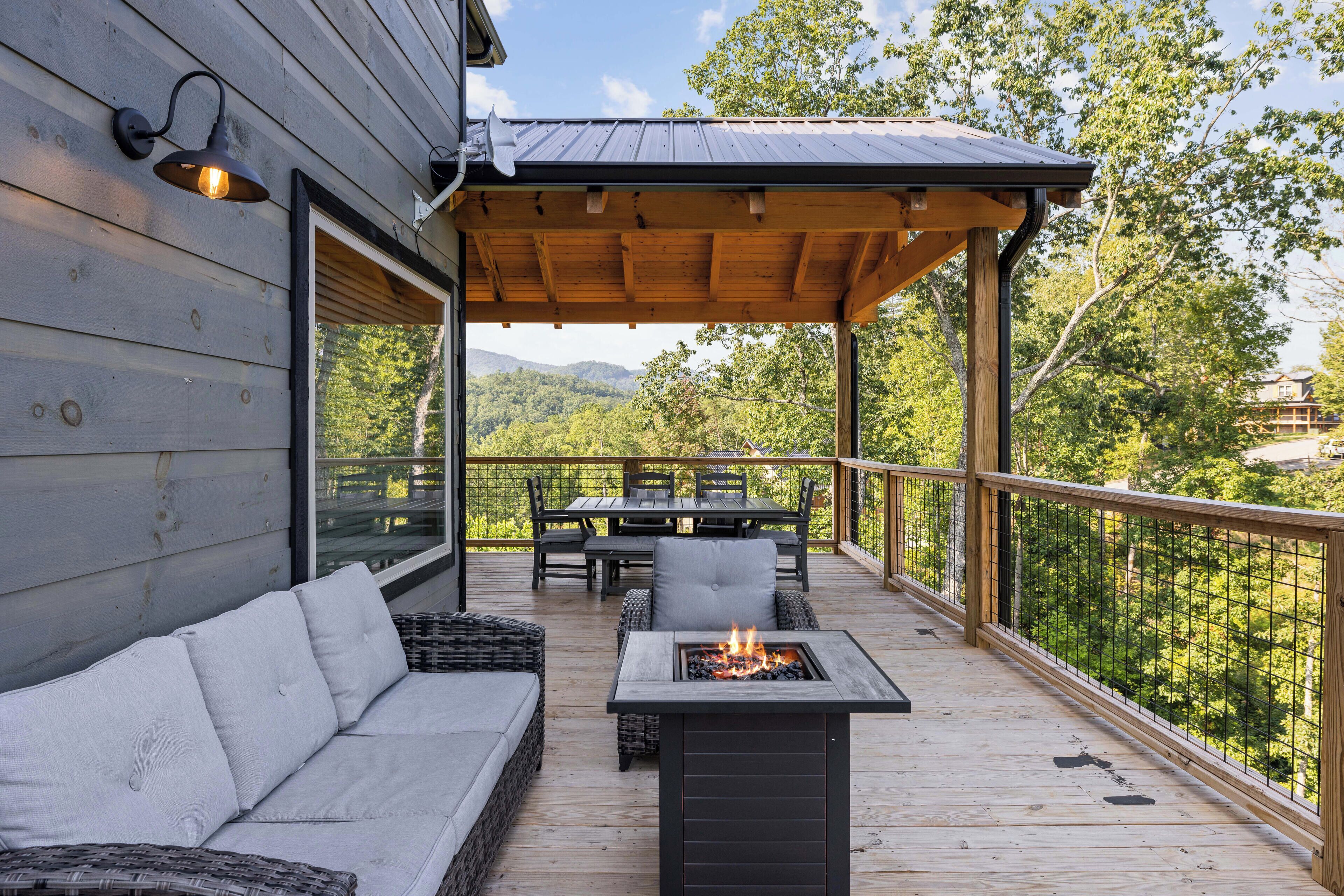 Une terrasse en bois avec un canapé, une table et un foyer extérieur.