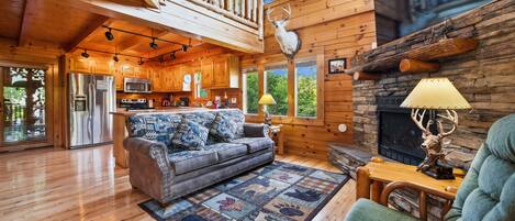 A spacious living area with a wooden ceiling, a fireplace, and a cozy seating arrangement.