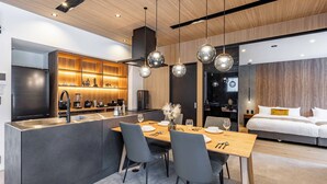 A modern kitchen with a central island, built-in appliances, and pendant lighting. - JAPAVISTA RUSUTSU (Rusutsu)