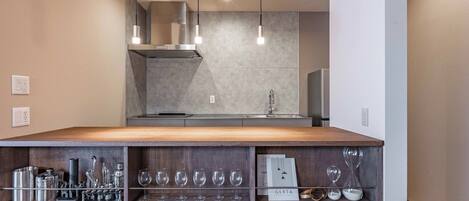 Una cocina moderna con encimera de madera, electrodomésticos de acero inoxidable y una estantería empotrada para vinos.