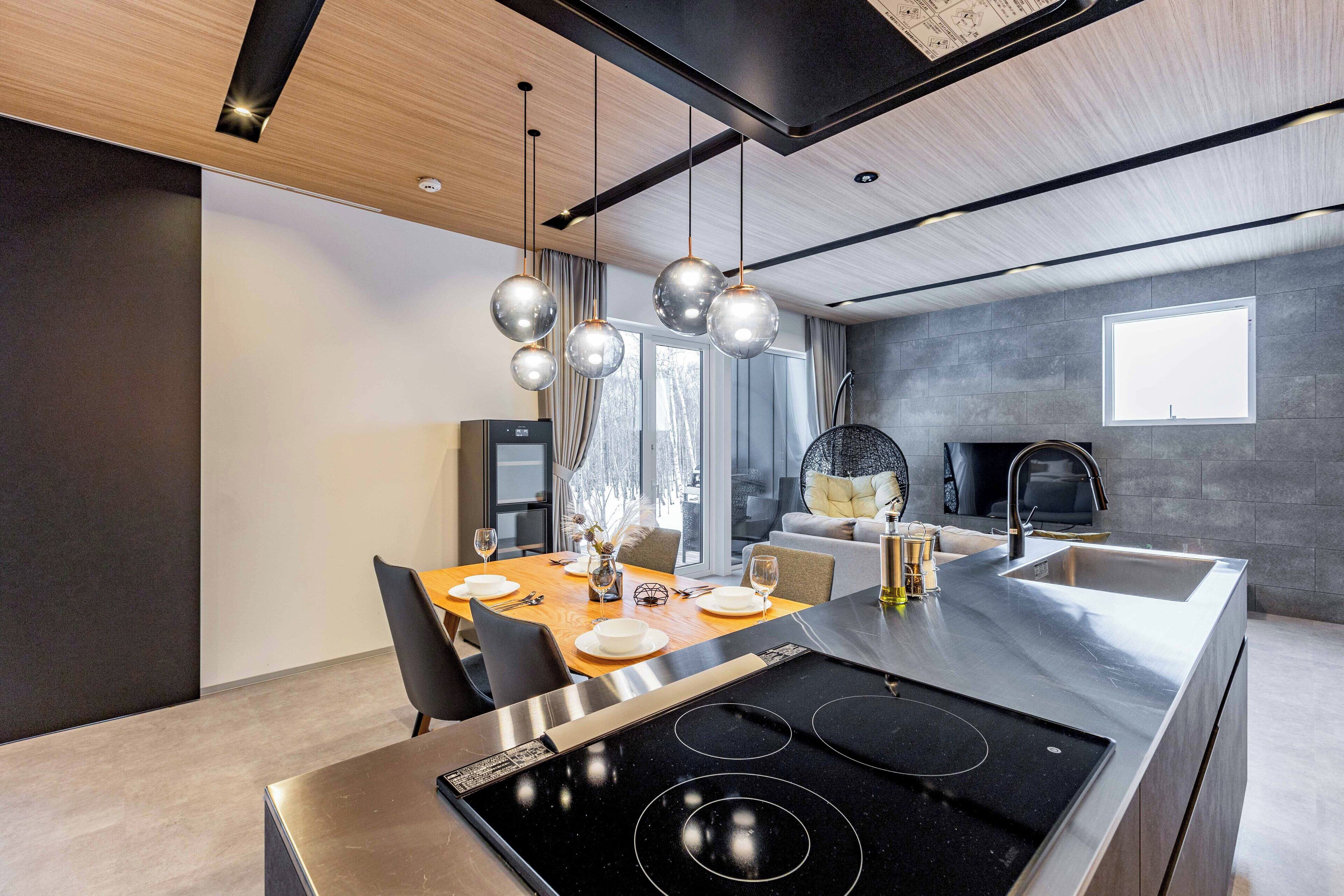 A modern kitchen with a central island, stainless steel appliances, and pendant lighting.