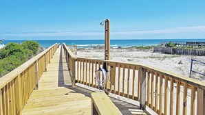 A wooden boardwalk leading to a beach with a clear view of the ocean. - Oceanfront House, Screen Porch, Boardwalk, Volleyball Sand Court, Game Room (Pawleys Island)
