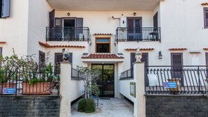 A building with a gated entrance, a small garden area, and a sign indicating private property.