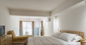 A bedroom with a bed, a wooden dresser, a TV, and a window with curtains. - Vecchio Bastione - Sup. Duplex by Wonderful Italy (Catania)