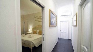 A hotel corridor with a bed, a framed picture, and a door. - Luxury Vale Villa. (Locorotondo)