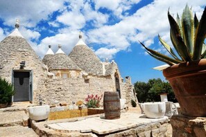 A stone building with multiple conical roofs, a door, and a potted plant.