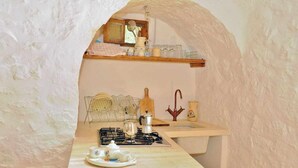 Una cocina compacta con estufa a gas, un lavabo y un escurreplatos.