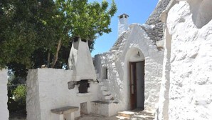 Un edificio tradicional blanco con una escalera de piedra que conduce a una puerta de madera.
