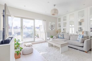 Departamento básico, 1 cama King size | Área de sala de estar | Televisión 