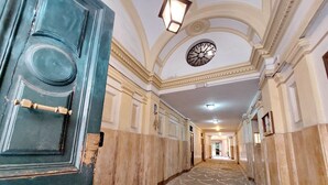 A hallway with a patterned carpet, a large circular ceiling decoration, and a blue door with a brass handle. - Laterano - Apartment for 4 pax with outdoor space close to the Coloseum (Roma)