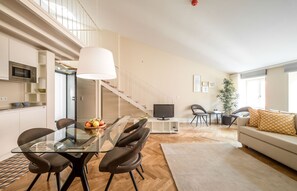 A modern living space with a dining area, kitchen, and seating area. - Mouzinho 160 (Porto)