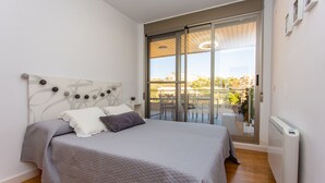 A bedroom with a bed, a radiator, and a sliding glass door leading to an outdoor area.