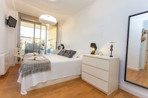 Un dormitorio con cama, mesita de noche, lámpara, cómoda y un espejo grande.