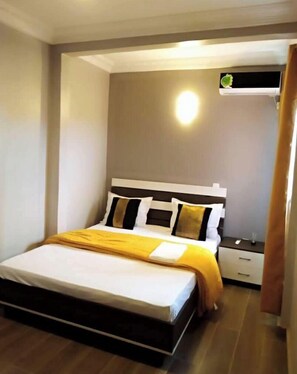 Relax in a stylish room with a comfortable bed, bedside table, and window offering a view of the outside.