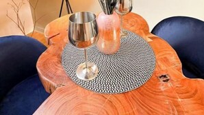 A dining table with a woven placemat, two wine glasses, and a vase with dried plants. - Studio Design - Unique - Centre Ville (Bagnères-de-Bigorre)