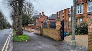 A residential street with houses, a gated driveway, and a clear road. - Apartment - Sleeps 2 - Parking - Wi-fi (Reading)