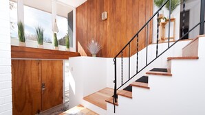 A modern staircase with wooden steps and black railings, leading to a landing with a white wall and a wooden door. - Mid Century Mountain Home on 3 acres - 10 Minutes to DGO - AC-Hot Tub-Views (Durango)