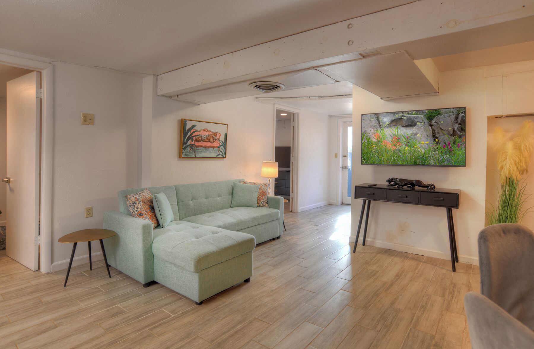 A living room with a sofa, a TV, and a small table.