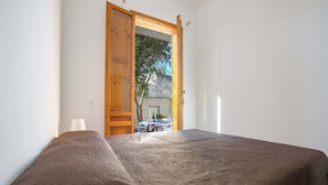 A bedroom with a bed, a wooden door, and a view of the outside. - 3208 Complesso Pergolesi - Bilo PT by Barbarhouse (Melendugno)