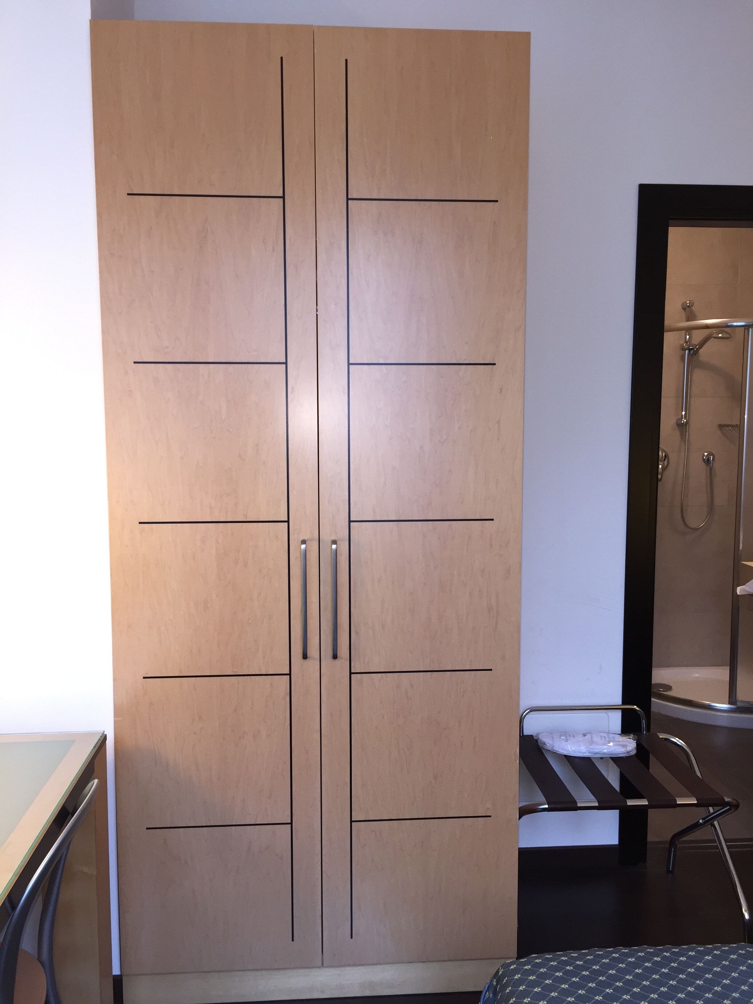 Une grande armoire à deux portes et dotée d’un miroir.