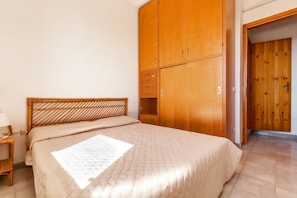 A bedroom with a wooden bed frame, a wooden wardrobe, and a wooden door. - 3210 Complesso Pergolesi - Appartamento SN by Barbarhouse (Melendugno)