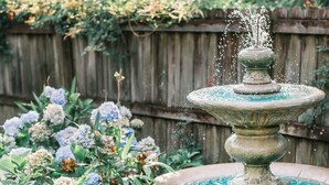 A garden with a stone fountain surrounded by hydrangea bushes. - Family & Pet Friendly Home in Quiet Neighborhood - Close to Beaches & Downtown! (Mount Pleasant)