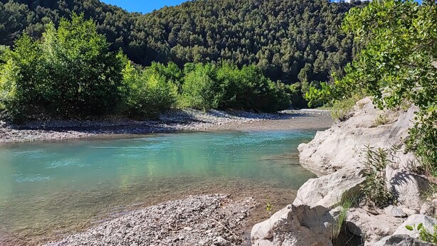 A river with clear water, surrounded by rocky terrain and dense forest. - Apartment in an old mill in a quiet area. Parc des Baronnies. (Aubres)