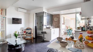Eine moderne Küche mit Essbereich, Fernseher und großem Fenster.