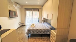 A modern bedroom with a bed, a TV mounted on the wall, and a window with a view of the outside. - Apartment Blu by Interhome (Rapallo)
