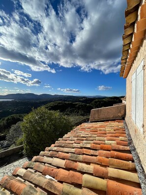 Una scala in pietra conduce a un edificio da cui si gode una vista su un paesaggio montuoso.