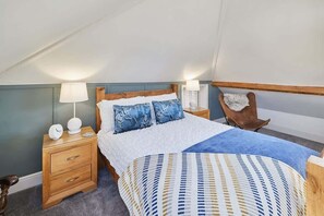 A bedroom with a bed, a nightstand, a lamp, and a chair. - Host & Stay | Mumbles Cottage (Whitby)