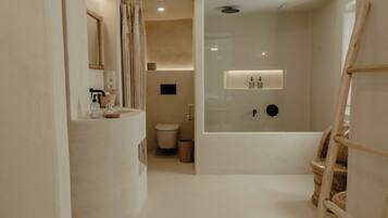 A modern bathroom with a bathtub, toilet, and sink.