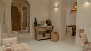 A cozy room with a wooden table, a bench, a small cabinet, and a hanging light fixture. - EntreArcos Casa Eco-Boutique (Vejer de la Frontera)