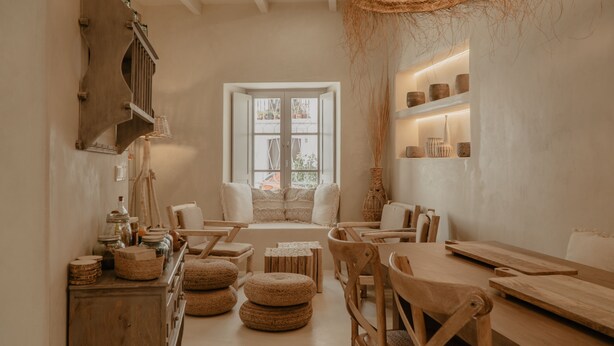 A cozy, well-lit room with a wooden bench, chairs, and a window with a view. - EntreArcos Casa Eco-Boutique (Vejer de la Frontera)