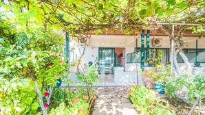 Un chemin de jardin qui mène à un bâtiment doté d’un patio couvert.